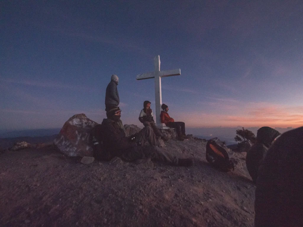 Wanderer warten am Gipfelkreuz des Volcán Barú auf den Sonnenaufgang